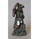 A Chinese patinated bronze model of a man holding coins above a lucky frog. 20 cm high.