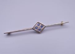 An unmarked 15 ct gold diamond and sapphire bar brooch. 6 cm long.