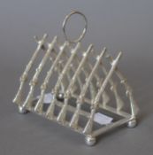 A silver plated rifle form toast rack. 11.5 cm long.