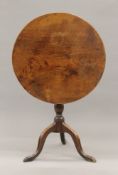 A George III elm topped tilt top tripod table. 68 cm diameter.