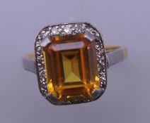 An 18 ct gold and platinum orange sapphire and diamond ring. Ring size O.