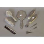 A quantity of silver backed brushes, etc., and a cased manicure set.