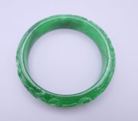 A carved jade bangle. 7.25 cm exterior diameter and 5.75 interior diameter.