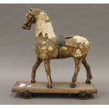 A 19th century pull along toy horse. 32.5 cm long.