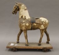 A 19th century pull along toy horse. 32.5 cm long.