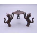 A small bronze model of cats holding a dish. 4 cm high.