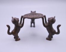 A small bronze model of cats holding a dish. 4 cm high.