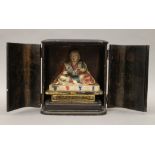 A 19th century carved and painted model of Buddha, housed in an ebonised case. The case 20.