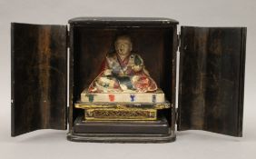 A 19th century carved and painted model of Buddha, housed in an ebonised case. The case 20.