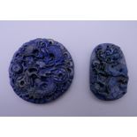 Two Chinese carved lapis pendants. The largest 5 cm diameter.