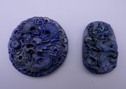 Two Chinese carved lapis pendants. The largest 5 cm diameter.