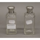 A pair of early 20th century French cut glass perfume bottles with 930 silver tops and inner glass