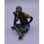A cold painted bronze model of a boy smoking a pipe. 5.5 cm high.