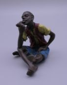 A cold painted bronze model of a boy smoking a pipe. 5.5 cm high.