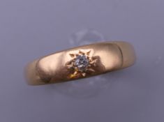 An 18 ct gold gypsy set diamond ring. Ring size Q. 3.1 grammes total weight.