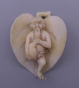 A small late 19th/early 20th century ivory carving formed as a figure on a leaf. 4.5 cm high.