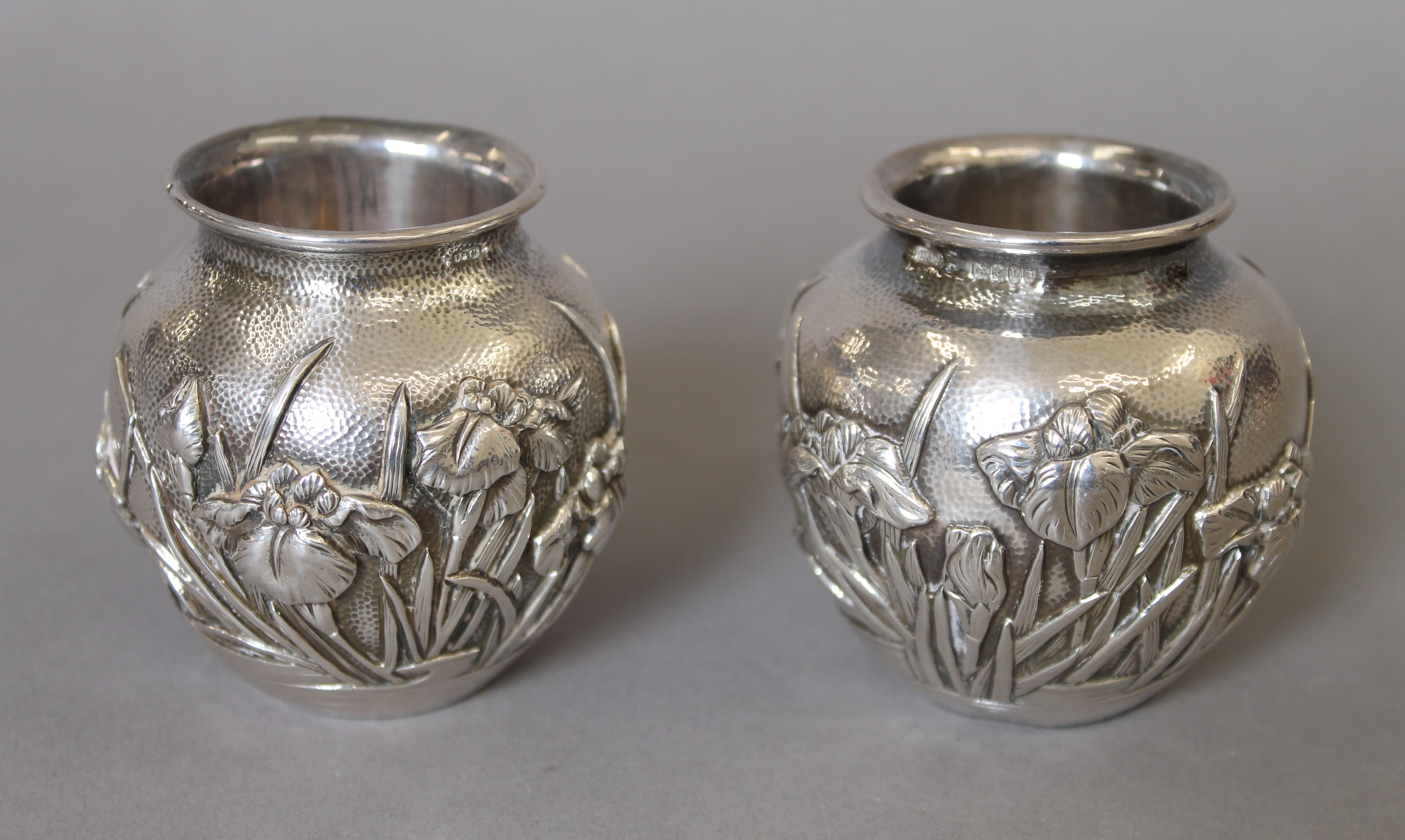 A pair of Japanese embossed silver vases, with Liberty & Co import marks. Each 6.5 cm high. 247.