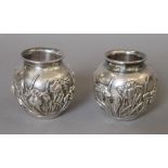 A pair of Japanese embossed silver vases, with Liberty & Co import marks. Each 6.5 cm high. 247.