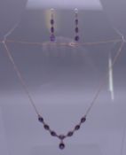 A 9 ct gold amethyst set necklace and earrings en-suite. The necklace 42 cm long. 7.