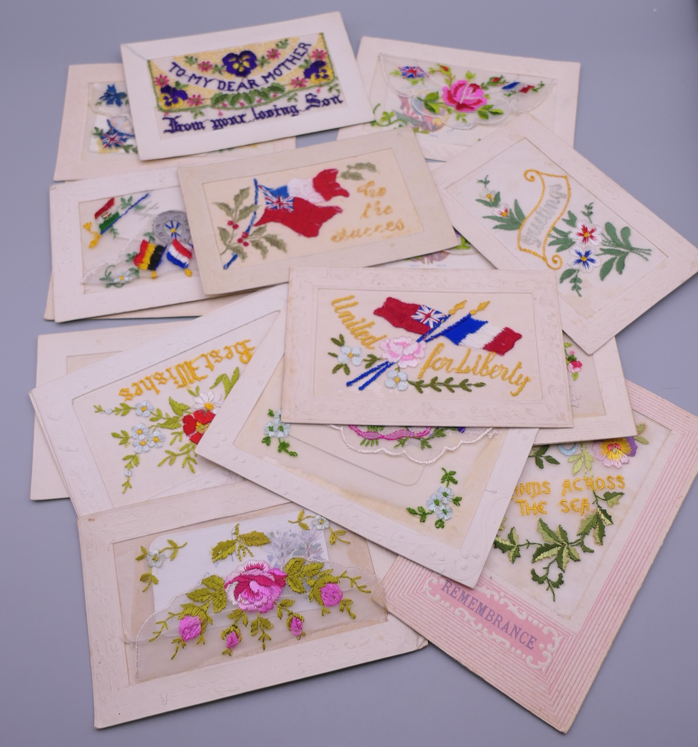 Seventeen World War I embroidered silk postcards including some with note cards.