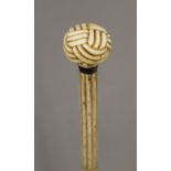 A 19th century carved whalebone walking stick with carved ivory sailors knot handle. 89 cm long.