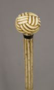 A 19th century carved whalebone walking stick with carved ivory sailors knot handle. 89 cm long.