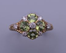 A 9 ct gold, peridot and diamond ring, with engravings to the sides. Ring size M/N.
