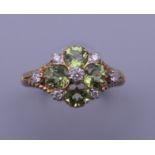 A 9 ct gold, peridot and diamond ring, with engravings to the sides. Ring size M/N.