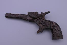 A late 19th century cast iron Lion cap gun, stamped Made in England, with some original paint.