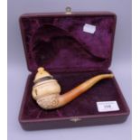 A boxed meerschaum carved pipe by Ismail Ozel depicting erotic scenes around the bowl. 17 cm long.