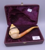 A boxed meerschaum carved pipe by Ismail Ozel depicting erotic scenes around the bowl. 17 cm long.