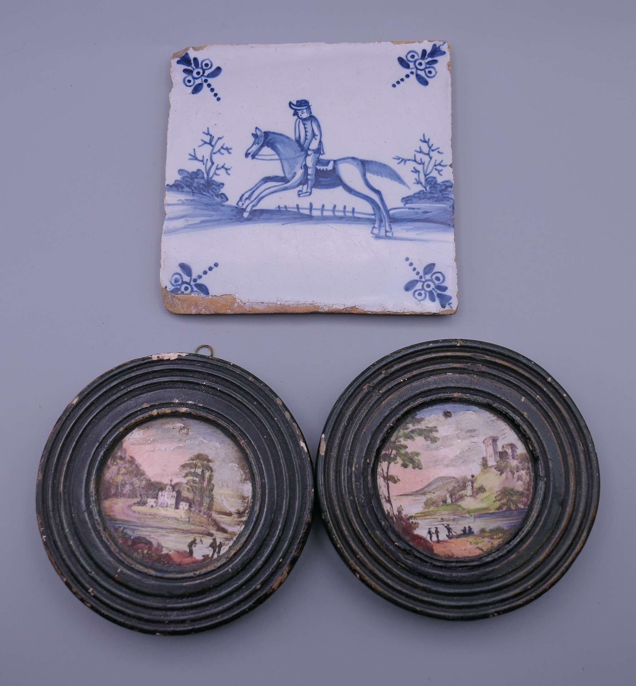 A Delft tile and two 19th century painted plaques. The former 12.5 cm wide.