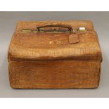 A Drew & Co crocodile skin travelling bag, containing some silver mounted accessories. 39 cm wide.