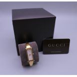 A ladies Gucci bracelet watch, in box, with paperwork and receipt.