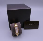 A ladies Gucci bracelet watch, in box, with paperwork and receipt.