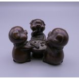 A bronze model of pigs playing dice. 4.5 cm high.