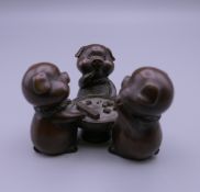 A bronze model of pigs playing dice. 4.5 cm high.