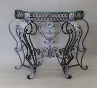A glass topped wrought iron console table. 87 cm wide.
