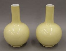 A pair of Chinese yellow ground porcelain vases, each with seal mark to base. 27 cm high.