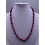 A red pearl bead necklace with a 14 ct gold clasp. 44 cm long.