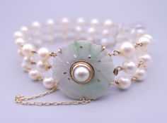 A 14 K gold jade and pearl bracelet. Approximately 18 cm long.