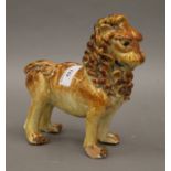 A glazed terracotta model of a lion. 20 cm long.