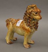 A glazed terracotta model of a lion. 20 cm long.