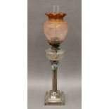 A silver plate oil lamp with orange etched shade. 77 cm high overall.