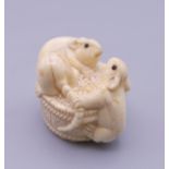 A carved bone netsuke formed as rats on a barrel. 3 cm high.