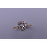 An 18 ct gold and platinum diamond daisy ring. Ring size N. 2.2 grammes total weight.