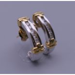 A pair of 18 ct yellow and white gold half hoop diamond earrings, with 18 ct gold butterfly clips.