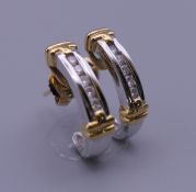A pair of 18 ct yellow and white gold half hoop diamond earrings, with 18 ct gold butterfly clips.