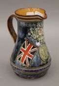 A Doulton Lambeth Flag of Pretoria jug. 20 cm high.