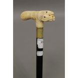 A walking stick with a carved bone handle formed as horse's heads. 90 cm long.